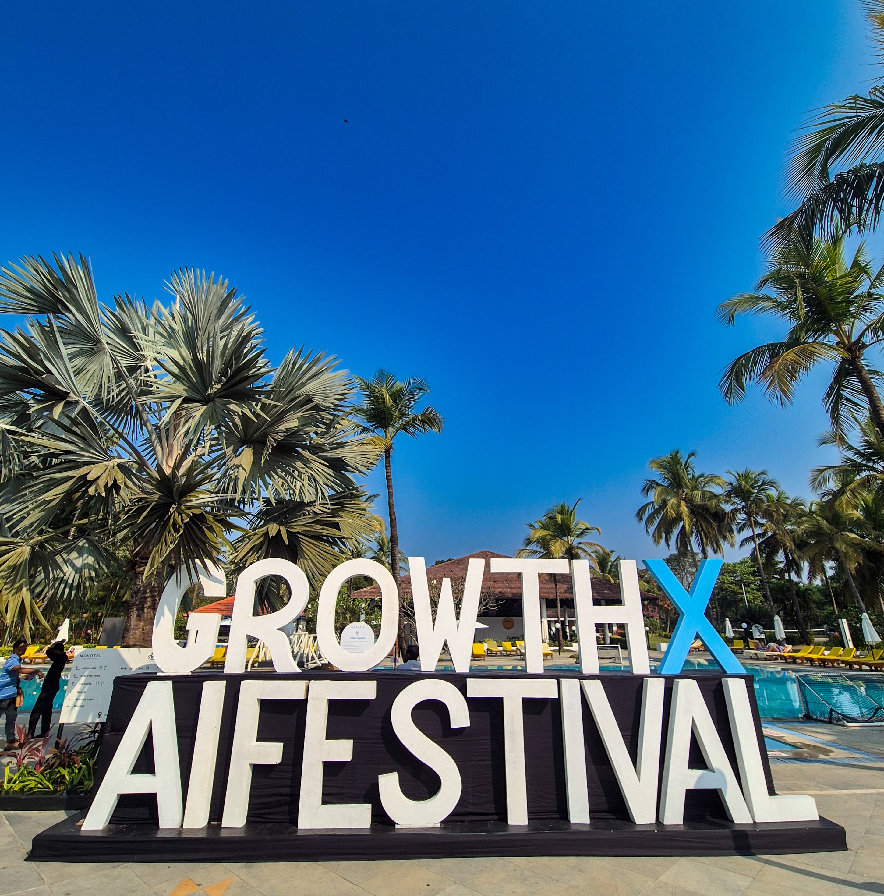 GrowthX AI Festival signage by a pool in Goa